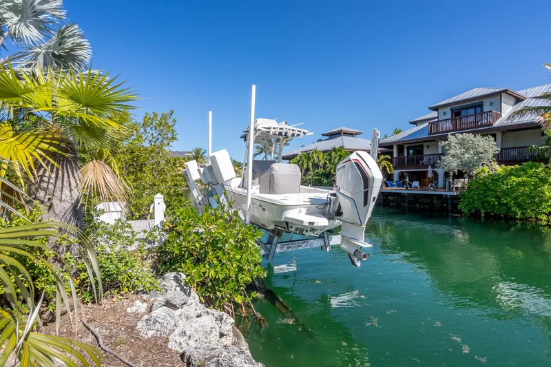 Slide: The Image of 2017 SeaVee 270Z boat docked by waterfront homes, surrounded by lush greenery. - 4