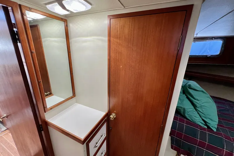 Slide: The Image of 1985 Tollycraft 48 Cockpit Motor Yacht interior with wooden drawers and carpeted floor. - 110