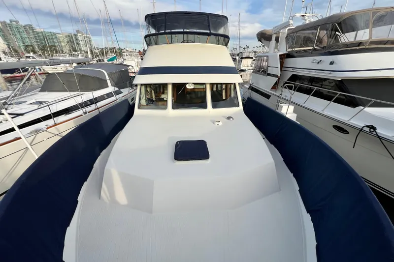 Slide: The Image of 1985 Tollycraft 48 Cockpit Motor Yacht docked at marina, showcasing spacious deck. - 13
