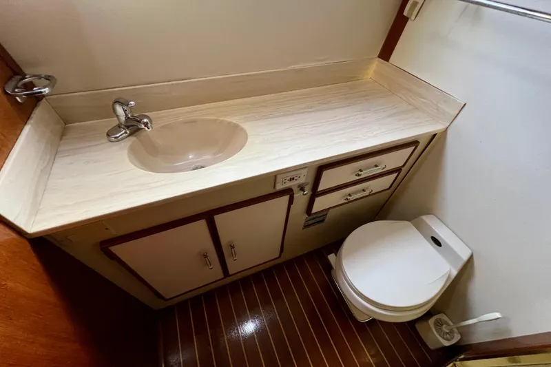 Slide: The Image of 1985 Tollycraft 48 Cockpit Motor Yacht bathroom with sink, toilet, and mirror. - 143