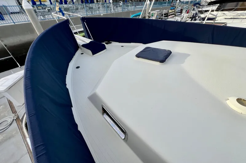 Slide: The Image of 1985 Tollycraft 48 Cockpit Motor Yacht docked, showcasing side deck and marina view. - 19