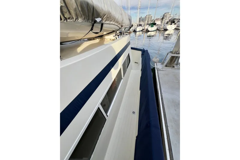 Slide: The Image of 1985 Tollycraft 48 Cockpit Motor Yacht docked, showcasing interior seating and exterior design. - 23