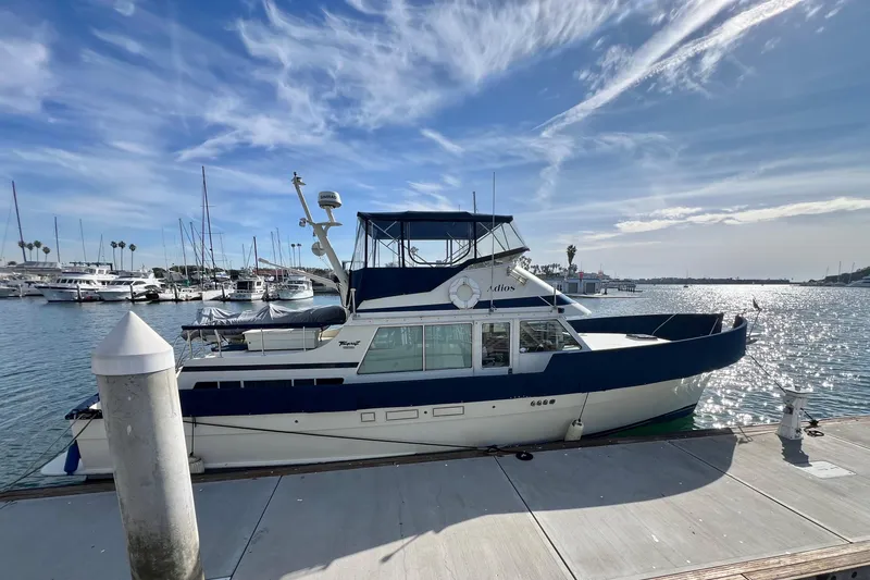 Slide: The Image of 1985 Tollycraft 48 Cockpit Motor Yacht docked at marina under blue sky. - 4