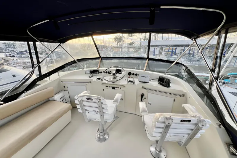 Slide: The Image of 1985 Tollycraft 48 Cockpit Motor Yacht at marina, sunset view, blue canopy. - 41