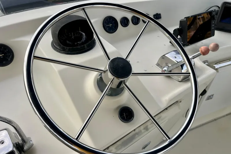 Slide: The Image of Cockpit view of 1985 Tollycraft 48 Cockpit Motor Yacht with steering wheel and navigation equipment. - 48