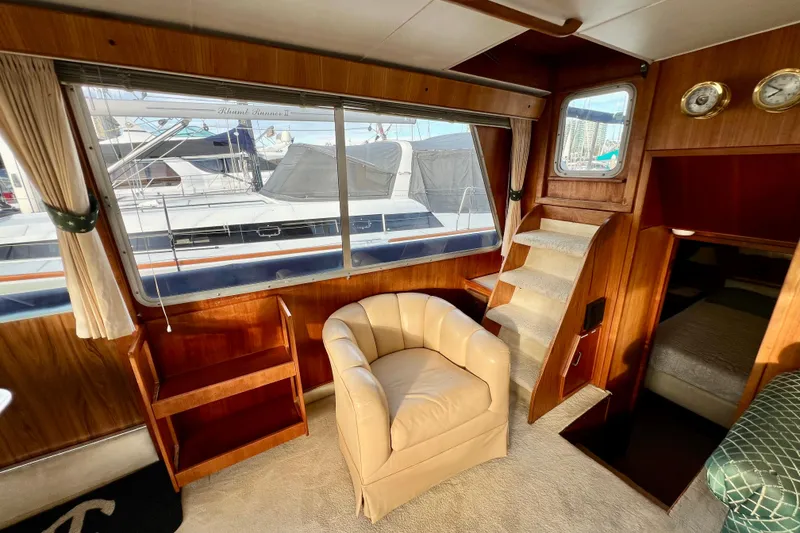 Slide: The Image of Interior view of 1985 Tollycraft 48 Cockpit Motor Yacht with carpeted stairs and wooden paneling. - 56