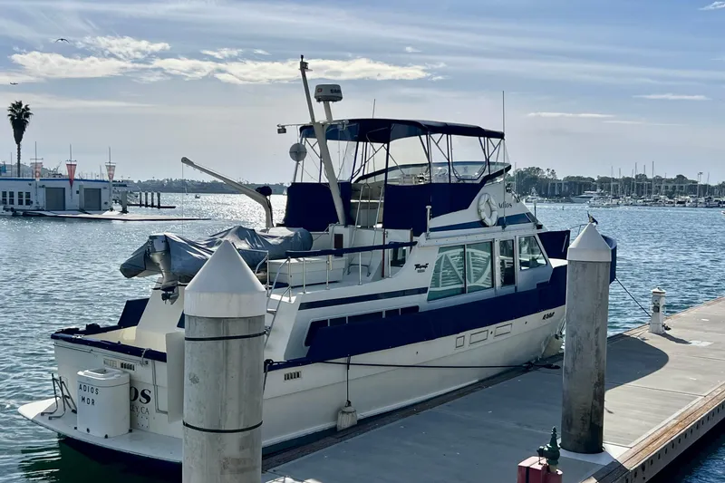 Slide: The Image of 1985 Tollycraft 48 Cockpit Motor Yacht docked at marina under clear sky. - 6