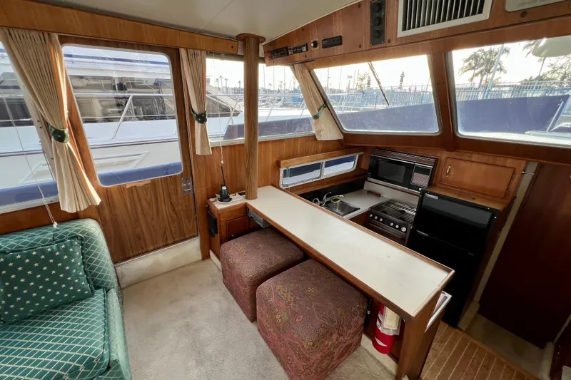 Slide: The Image of Interior of 1985 Tollycraft 48 Cockpit Motor Yacht with green sofa and wooden accents. - 62