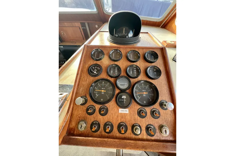Slide: The Image of 1985 Tollycraft 48 Cockpit Motor Yacht helm with gauges, controls, and Simrad equipment. - 66