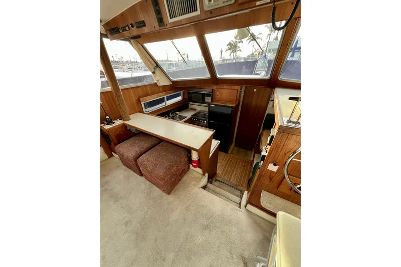 Slide: The Image of 1985 Tollycraft 48 Cockpit Motor Yacht interior with helm, chair, and stairs. - 84
