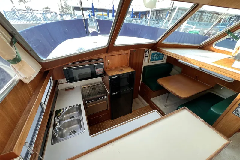 Slide: The Image of 1985 Tollycraft 48 Cockpit Motor Yacht interior with kitchen and dining area. - 87