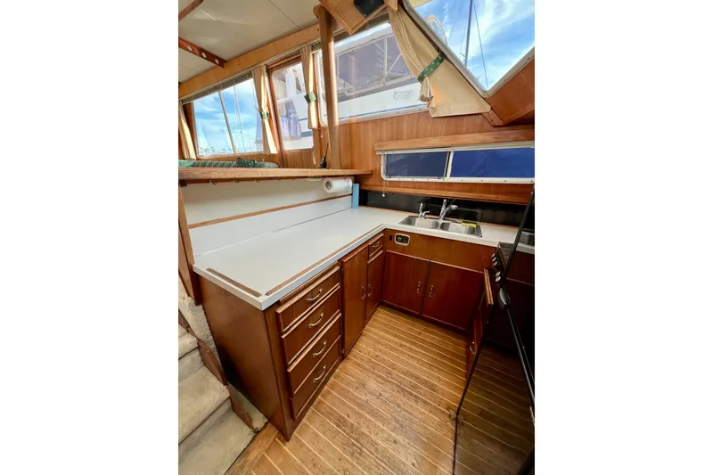 Slide: The Image of 1985 Tollycraft 48 Cockpit Motor Yacht kitchen with wooden cabinets and stainless steel sink. - 89