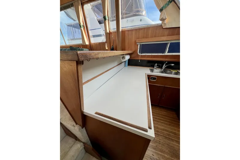 Slide: The Image of 1985 Tollycraft 48 Cockpit Motor Yacht kitchen with wooden cabinets and dual sink. - 91