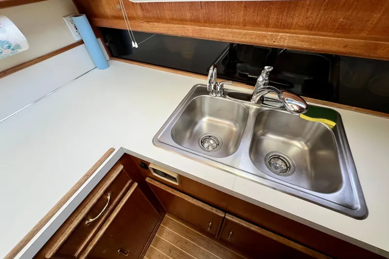 Slide: The Image of 1985 Tollycraft 48 Cockpit Motor Yacht kitchen with wood cabinetry and modern appliances. - 94