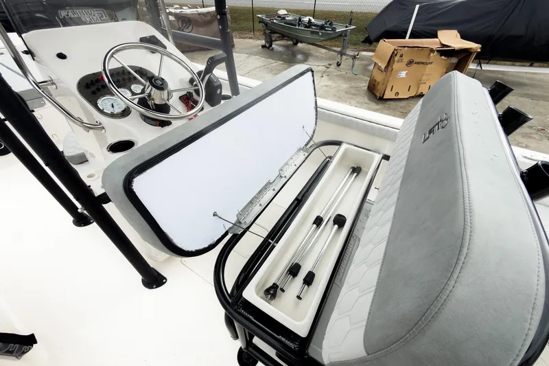 Slide: The Image of 2026 Carolina Skiff 21 LS boat interior with open storage compartment and steering console. - 12