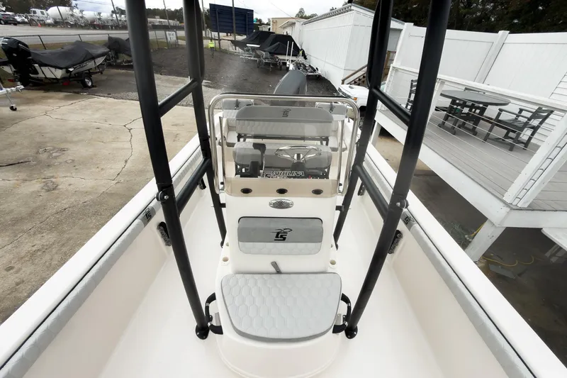 Slide: The Image of 2026 Carolina Skiff 21 LS boat interior with console and seating, docked outdoors. - 21