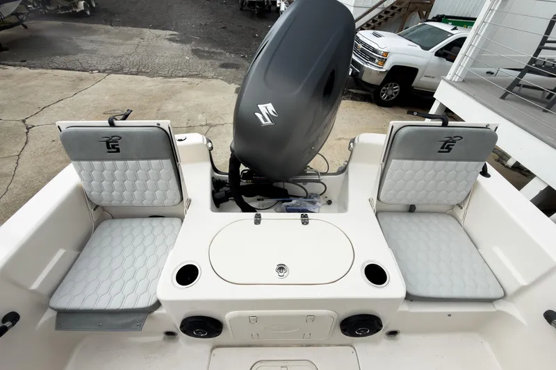 Slide: The Image of 2026 Carolina Skiff 21 LS boat interior with seating and motor, docked outdoors. - 6