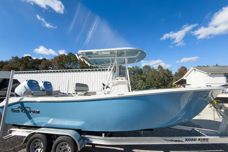 Slide: The Image of 2026 Sea Chaser 24 HFC DE boat on trailer, blue hull, dual engines, clear sky background. - 37
