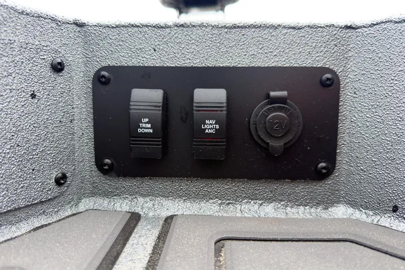 Slide: The Image of Control panel of 2026 Excel Bay Pro Elite 230 boat with switches and 12V outlet. - 27