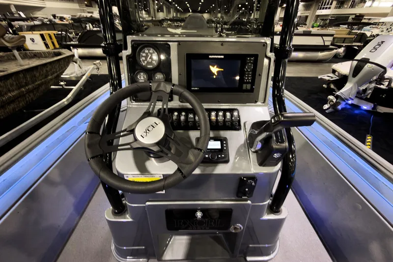 Slide: The Image of 2026 Excel 230 Bay Pro Elite boat dashboard with steering wheel and navigation display. - 6