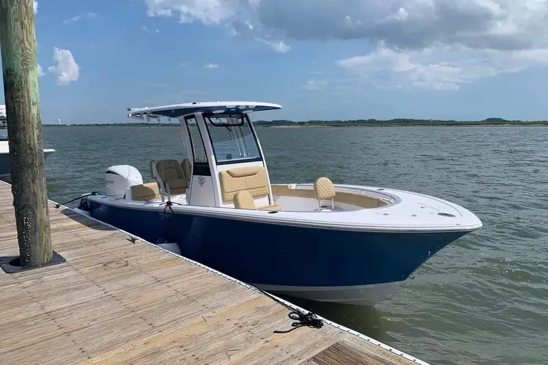The Image of 2025 Sportsman Heritage 231 Center Console boat docked by the water. - 1