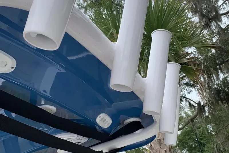 Slide: The Image of 2025 Sportsman Heritage 231 Center Console boat rod holders, blue and white design, outdoor setting. - 12