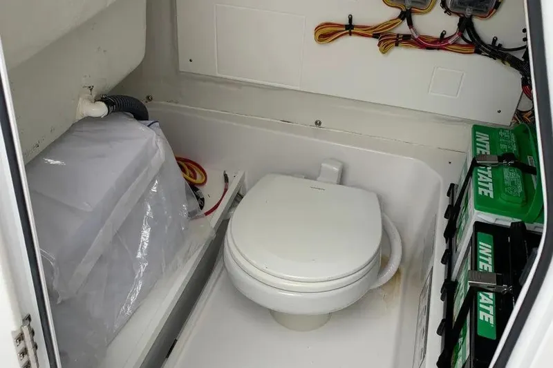 Slide: The Image of 2025 Sportsman Heritage 231 Center Console boat interior with toilet and battery storage. - 8