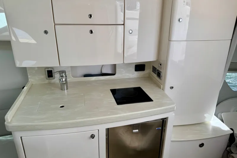 Slide: The Image of Modern kitchen area in a 2019 Intrepid 407 Cuddy boat, featuring sleek cabinetry and appliances. - 14