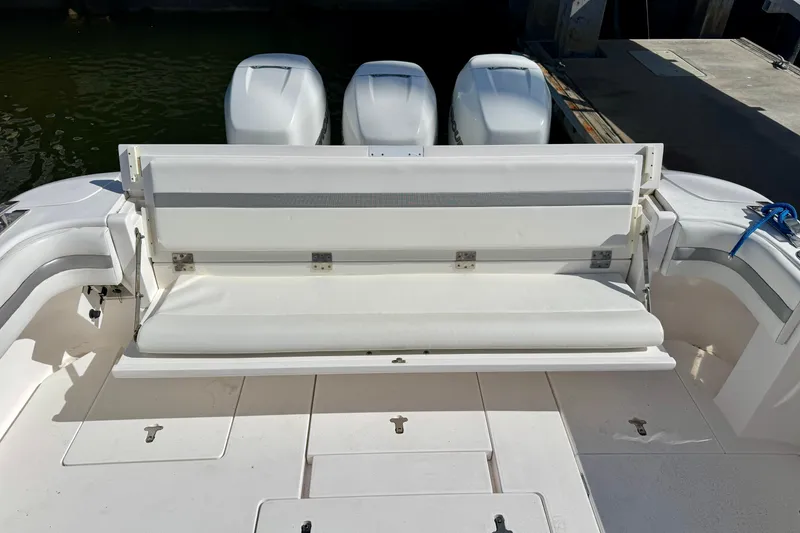 Slide: The Image of 2019 Intrepid 407 Cuddy boat with white seating and triple outboard engines. - 15