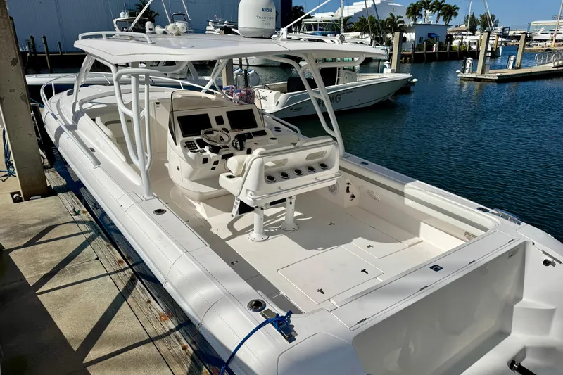 Slide: The Image of 2019 Intrepid 407 Cuddy boat docked at marina, featuring spacious cockpit and helm. - 5