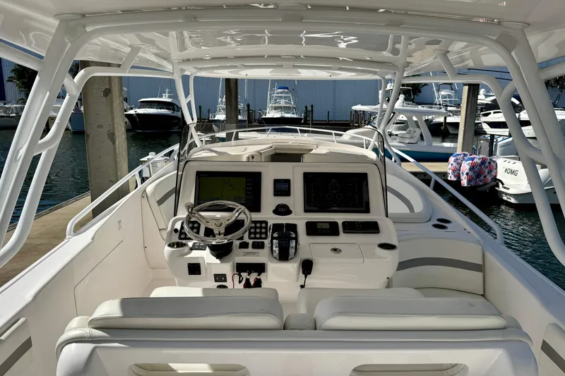Slide: The Image of 2019 Intrepid 407 Cuddy boat interior with advanced navigation system at marina. - 8