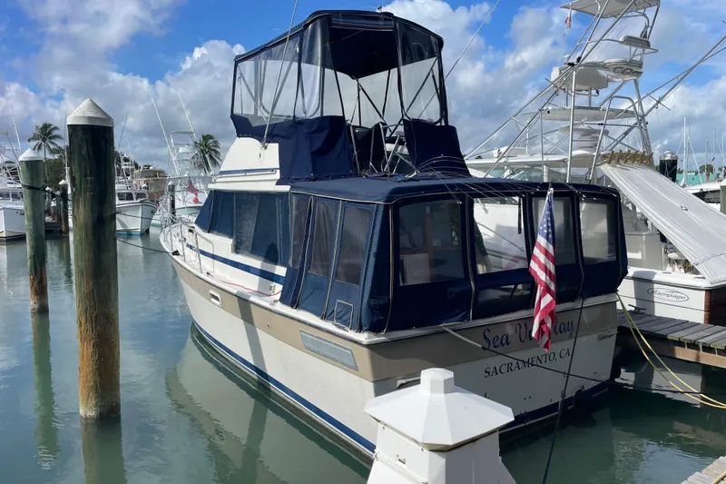 The Image of 1983 Bayliner 3270 Explorer docked at marina with American flag. - 0