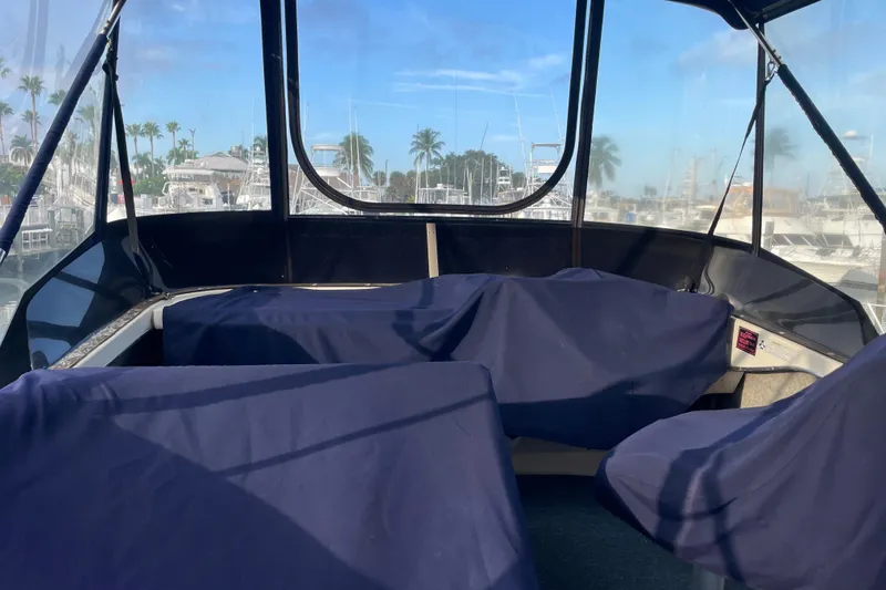 Slide: The Image of 1983 Bayliner 3270 Explorer boat interior with covered seating, marina view. - 10