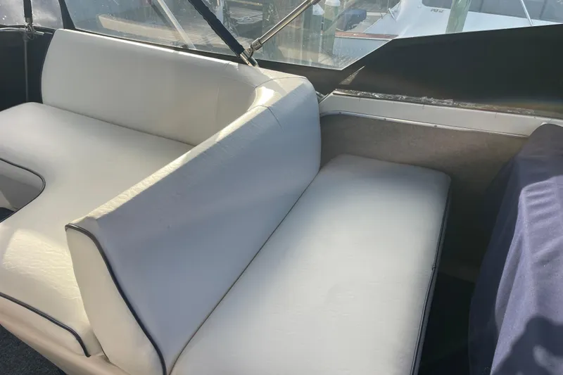 Slide: The Image of White seating area on a 1983 Bayliner 3270 Explorer boat, with sunlight streaming through windows. - 8