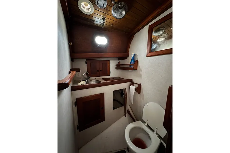 Slide: The Image of 1977 Westsail Cutter bathroom with wooden cabinetry and compact design. - 24