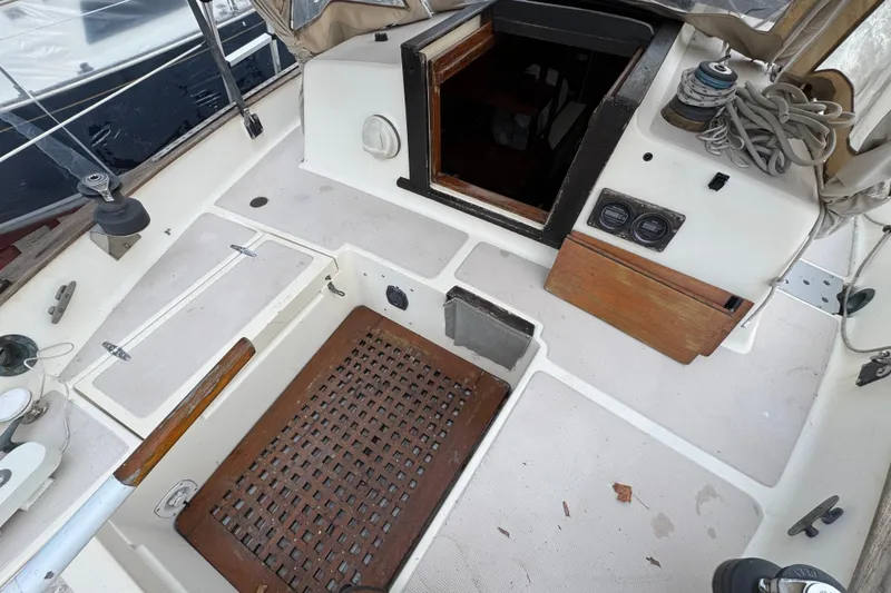 Slide: The Image of 1977 Westsail Cutter cockpit with wooden accents and nautical equipment. - 33