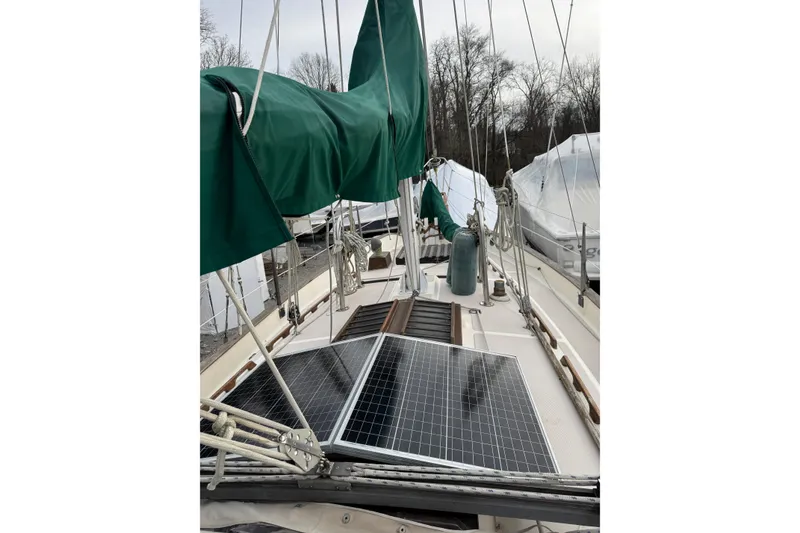 Slide: The Image of 1977 Westsail Cutter sailboat deck with solar panels and green sail cover. - 34