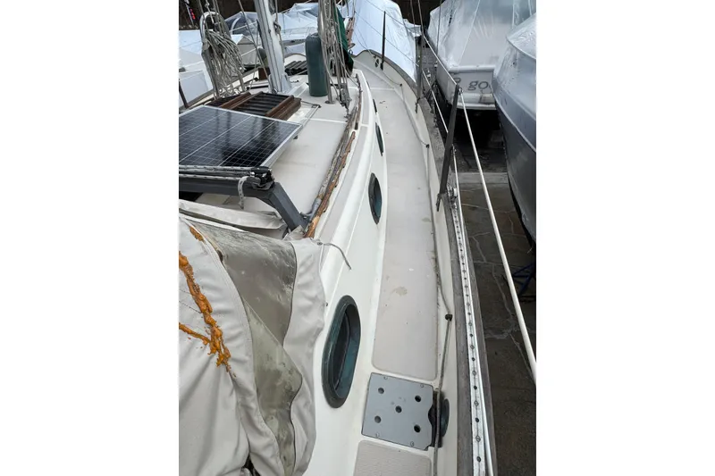 Slide: The Image of 1977 Westsail Cutter sailboat deck with solar panel and weathered canvas cover. - 36