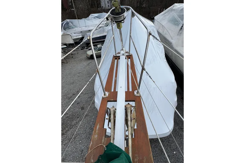 Slide: The Image of 1977 Westsail Cutter sailboat deck with rigging, covered in white tarp. - 39