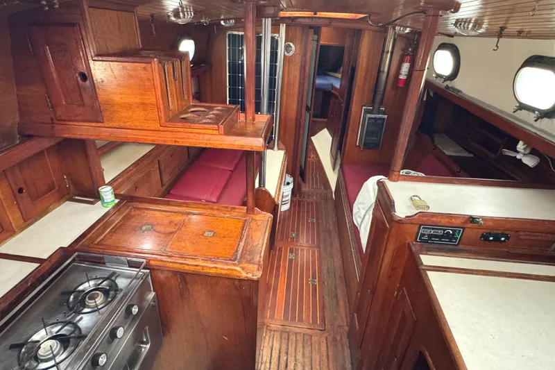 Slide: The Image of 1977 Westsail Cutter interior with wooden cabinetry, galley, and seating area. - 7