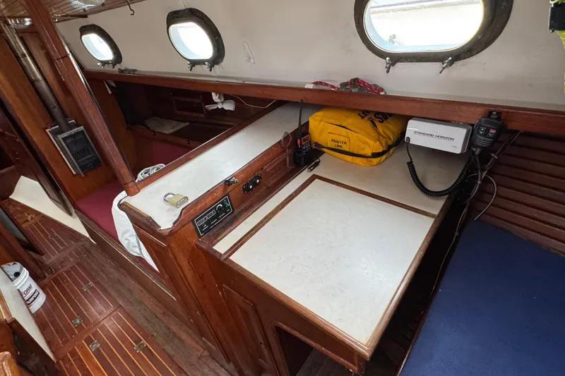 Slide: The Image of 1977 Westsail Cutter interior with navigation station, wood paneling, and portholes. - 8