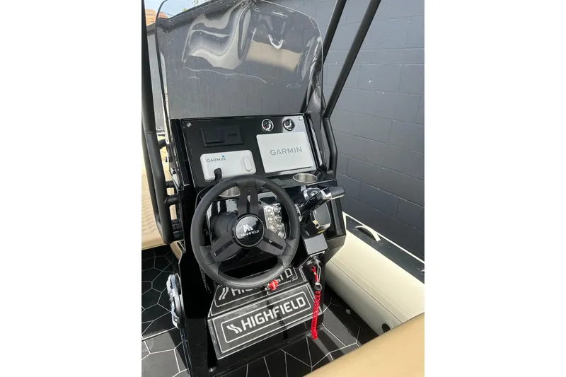 Slide: The Image of 2024 Highfield Sport 560 boat dashboard with Garmin navigation system and steering wheel. - 4