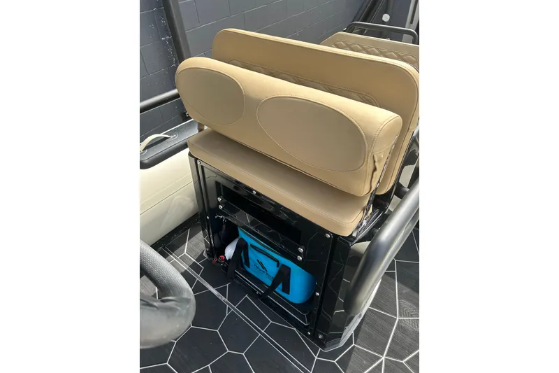 Slide: The Image of 2024 Highfield Sport 560 boat seat with storage compartment, featuring tan upholstery. - 6