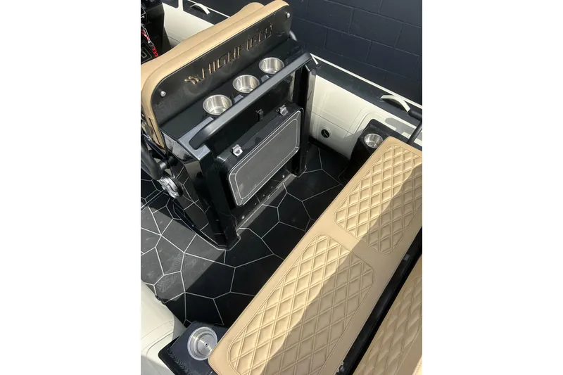 Slide: The Image of 2024 Highfield Sport 560 interior with tan diamond-stitched seats and cup holders. - 8