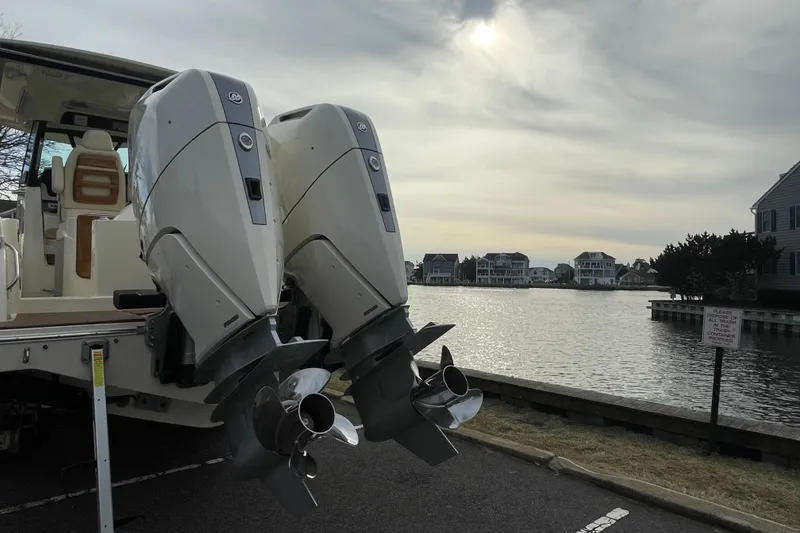 Slide: The Image of 2026 Chris-Craft 310 Catalina with dual outboard engines by a scenic waterfront. - 11