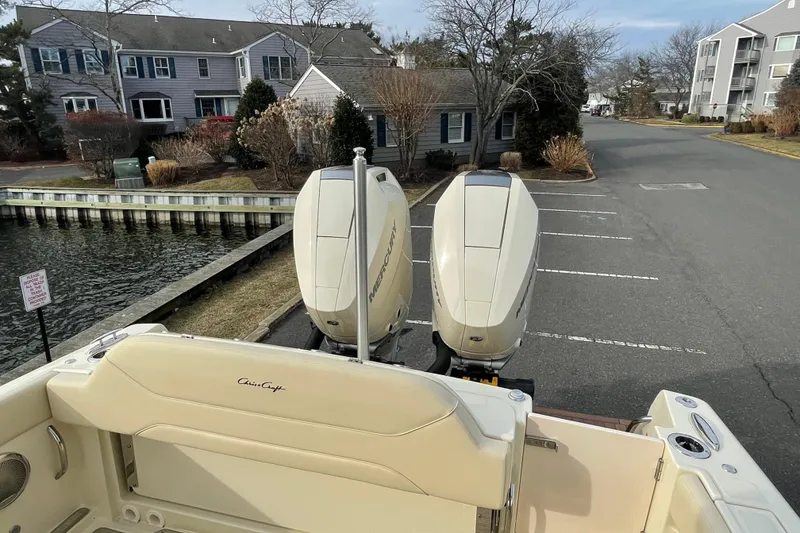 Slide: The Image of 2026 Chris-Craft 310 Catalina with dual Mercury outboard engines, parked near waterfront homes. - 20