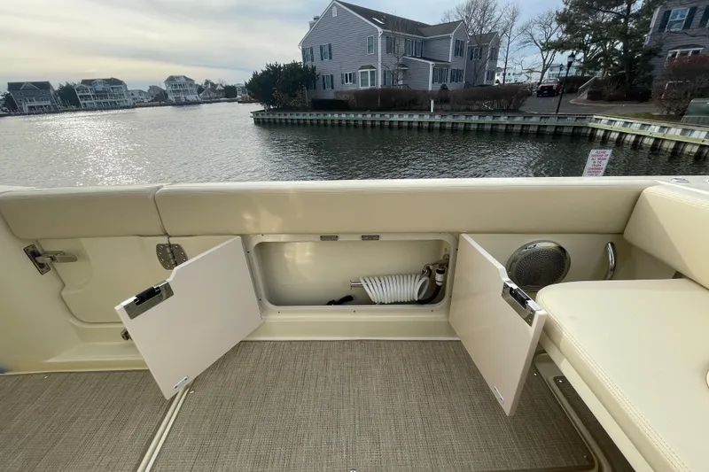 Slide: The Image of 2026 Chris-Craft 310 Catalina boat interior with open storage compartments by waterfront homes. - 25
