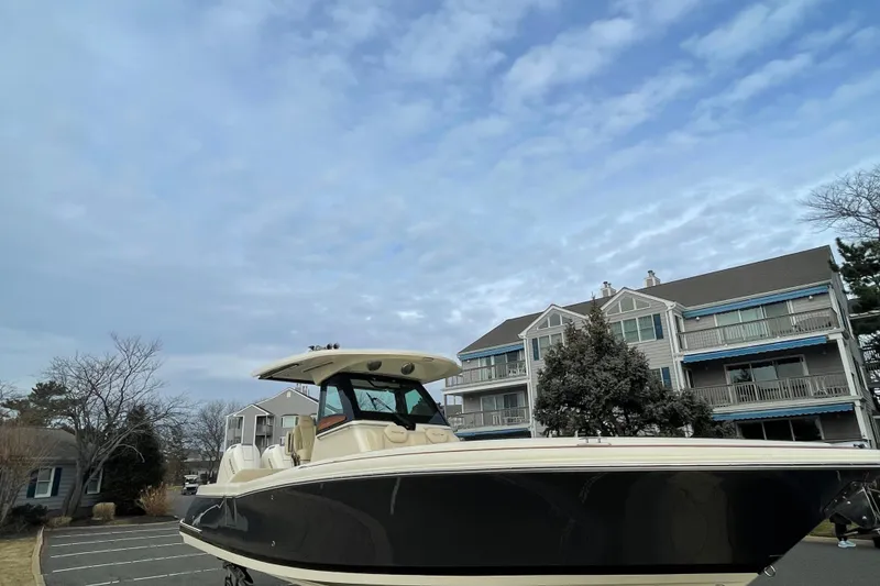 Slide: The Image of 2026 Chris-Craft 310 Catalina boat parked near residential buildings under a cloudy sky. - 3