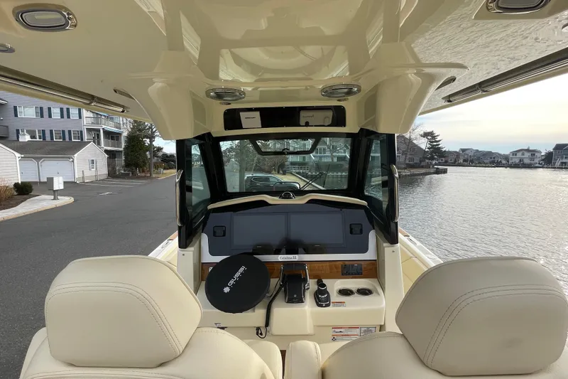 Slide: The Image of 2026 Chris-Craft 310 Catalina boat interior with helm, docked near waterfront homes. - 33