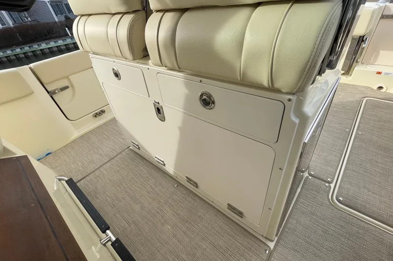 Slide: The Image of 2026 Chris-Craft 310 Catalina interior seating and storage area, featuring beige upholstery. - 39